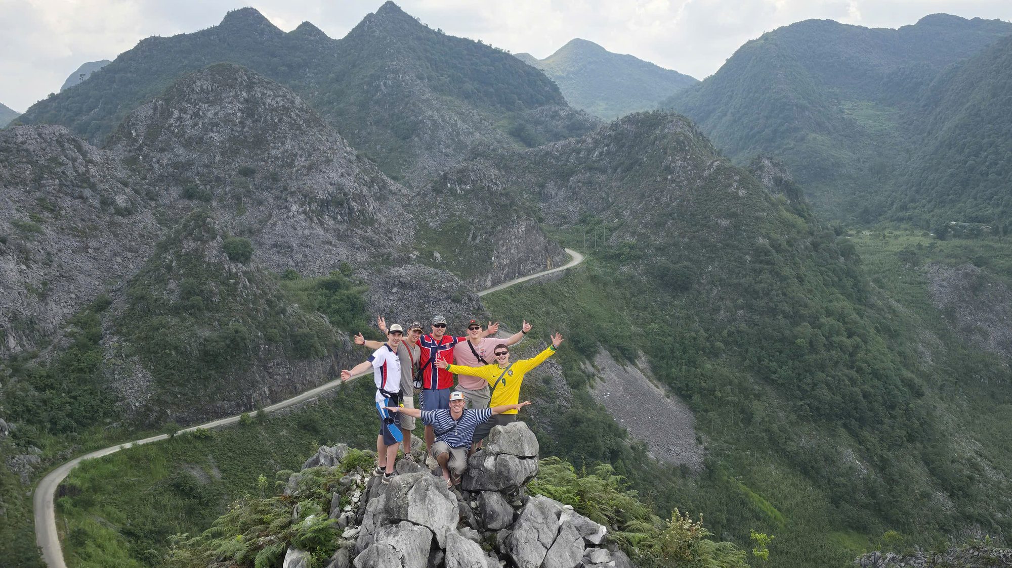 Travellers standing above the switchback road on the Ha Giang Loop in northern Vietnam