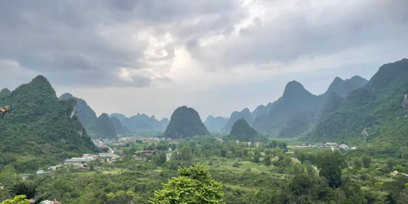 A wide green valley of karst peaks and terraced fields in Ha Giang province under heavy cloud, April 2026