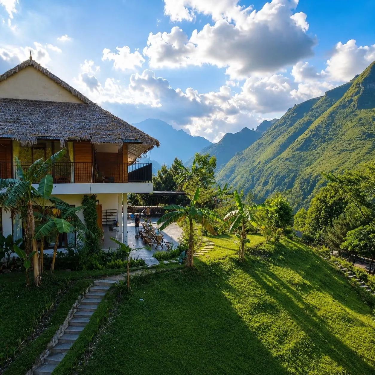 The thatched main building at Jashill Homestay with the Du Gia valley behind it, August 2026