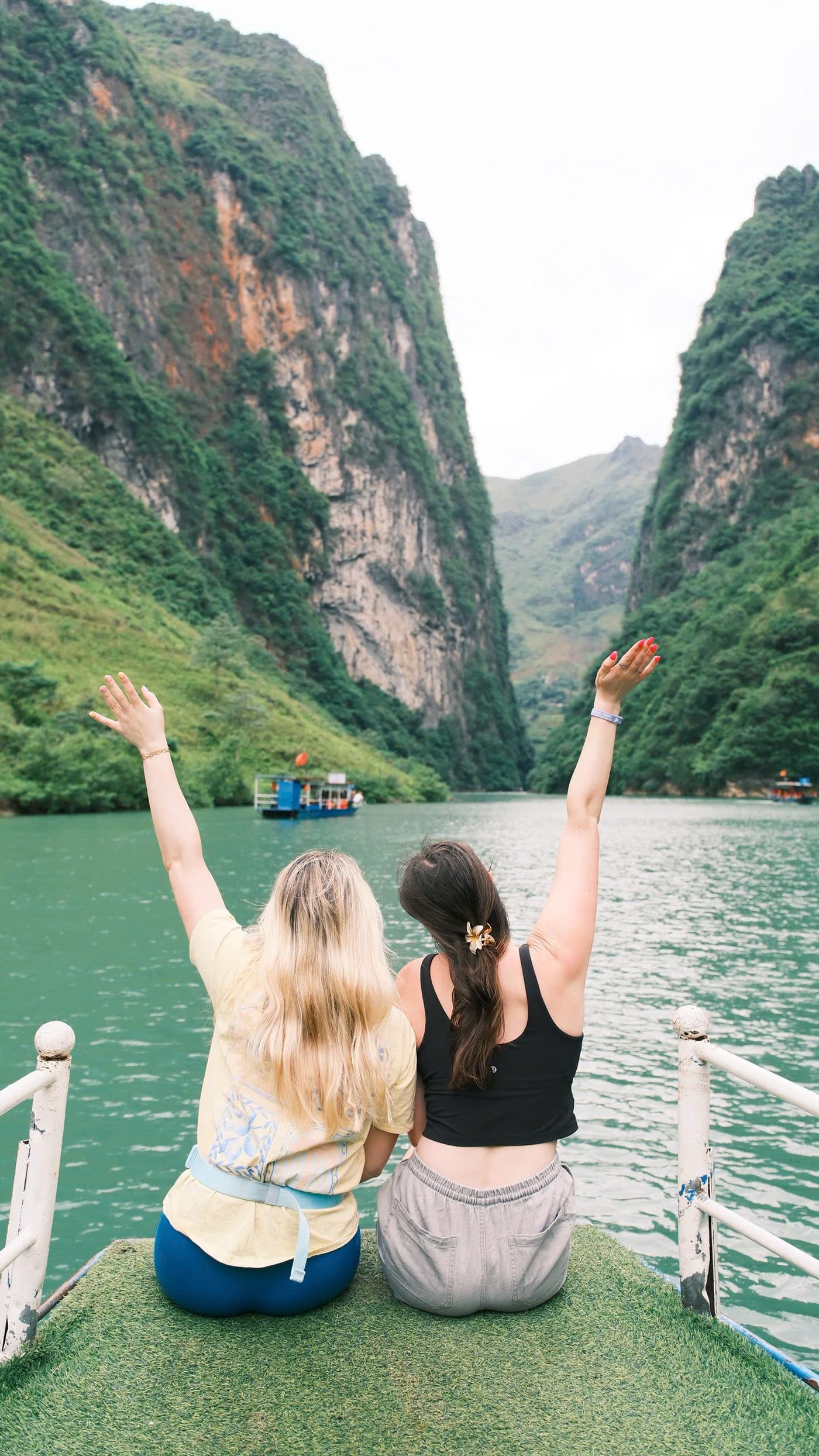 Travellers looking out over the Nho Que river from a boat below the Ma Pi Leng pass