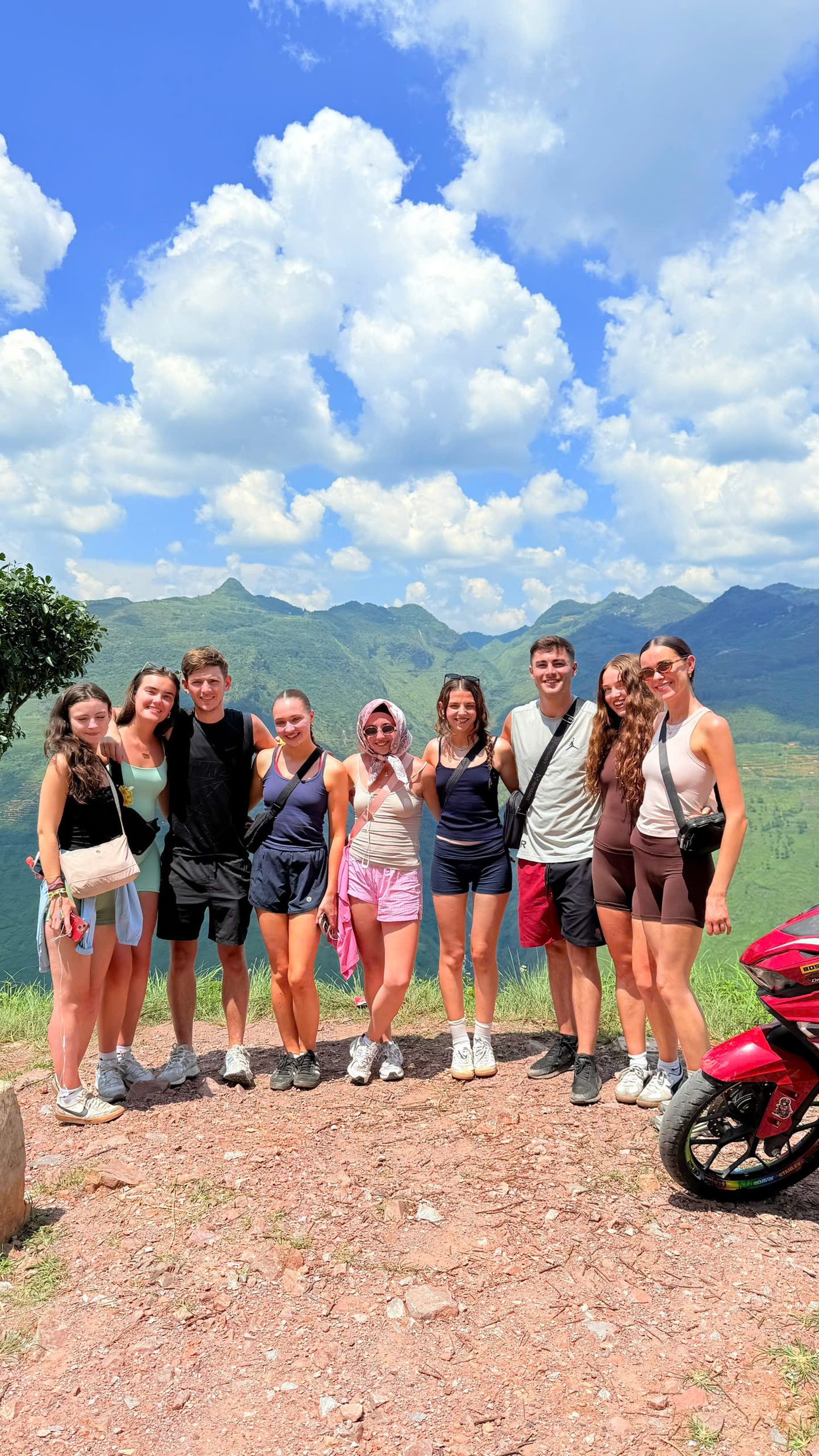 A group of travellers beside their motorbike at a viewpoint on the Ha Giang Loop