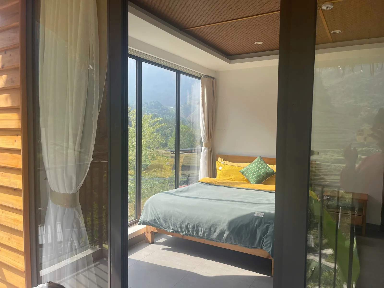 Bedroom with curtained mountain-view window at Jashill Homestay, Du Gia, August 2026