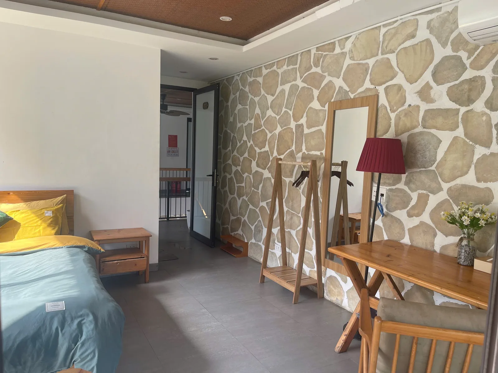 Room with stone-clad wall and writing desk at Jashill Homestay, Du Gia, August 2026