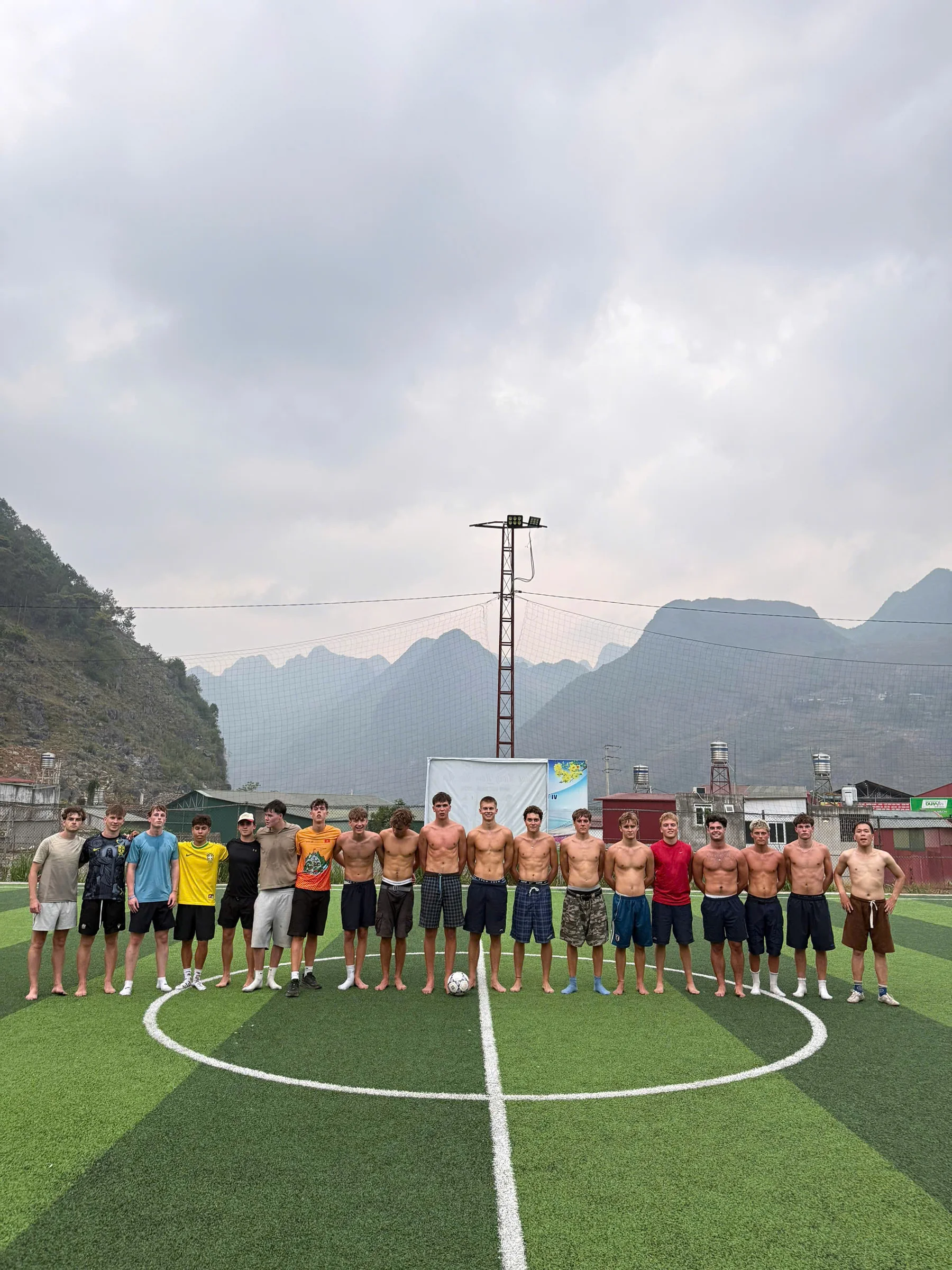 A group of riders gathered on rocky ground beside their motorbikes in Ha Giang, May 2026