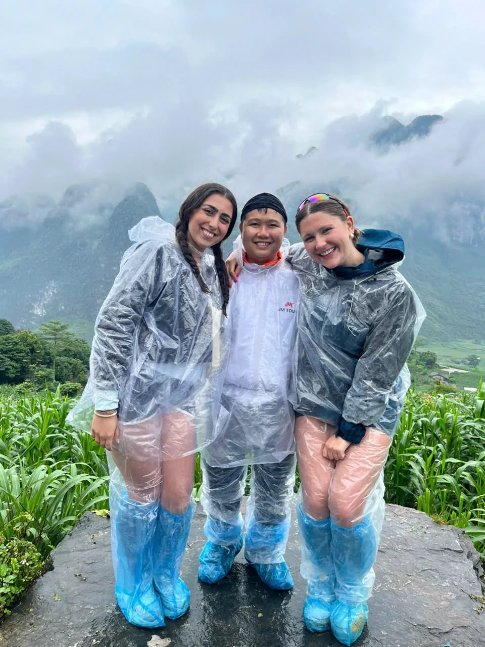 A group of travellers sitting together outdoors at a stop in Ha Giang, June 2026