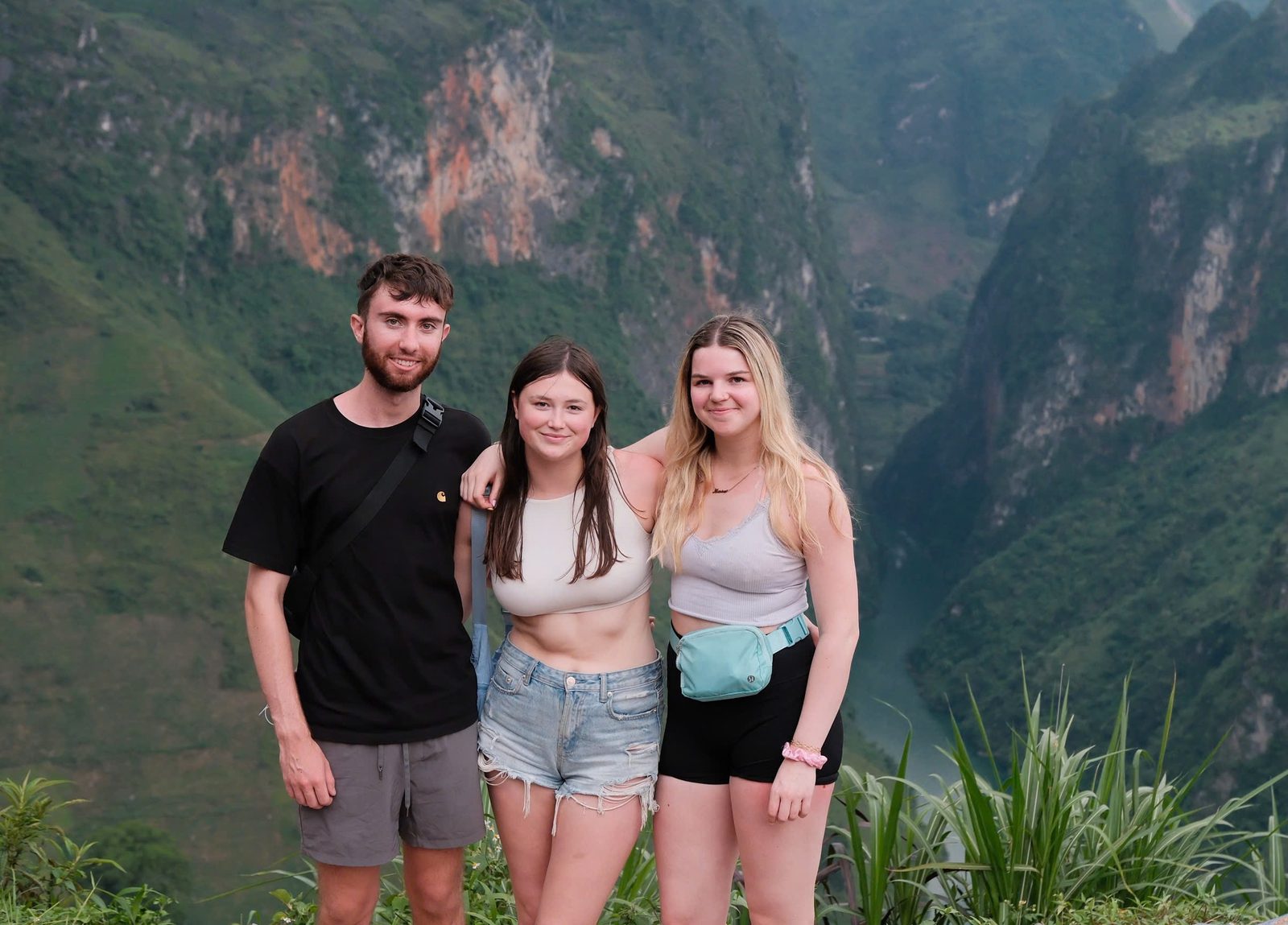 Three travellers at a viewpoint over the limestone mountains of the Ha Giang Loop